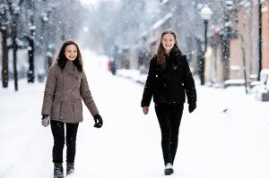 Девушки гуляют по заснеженной улице